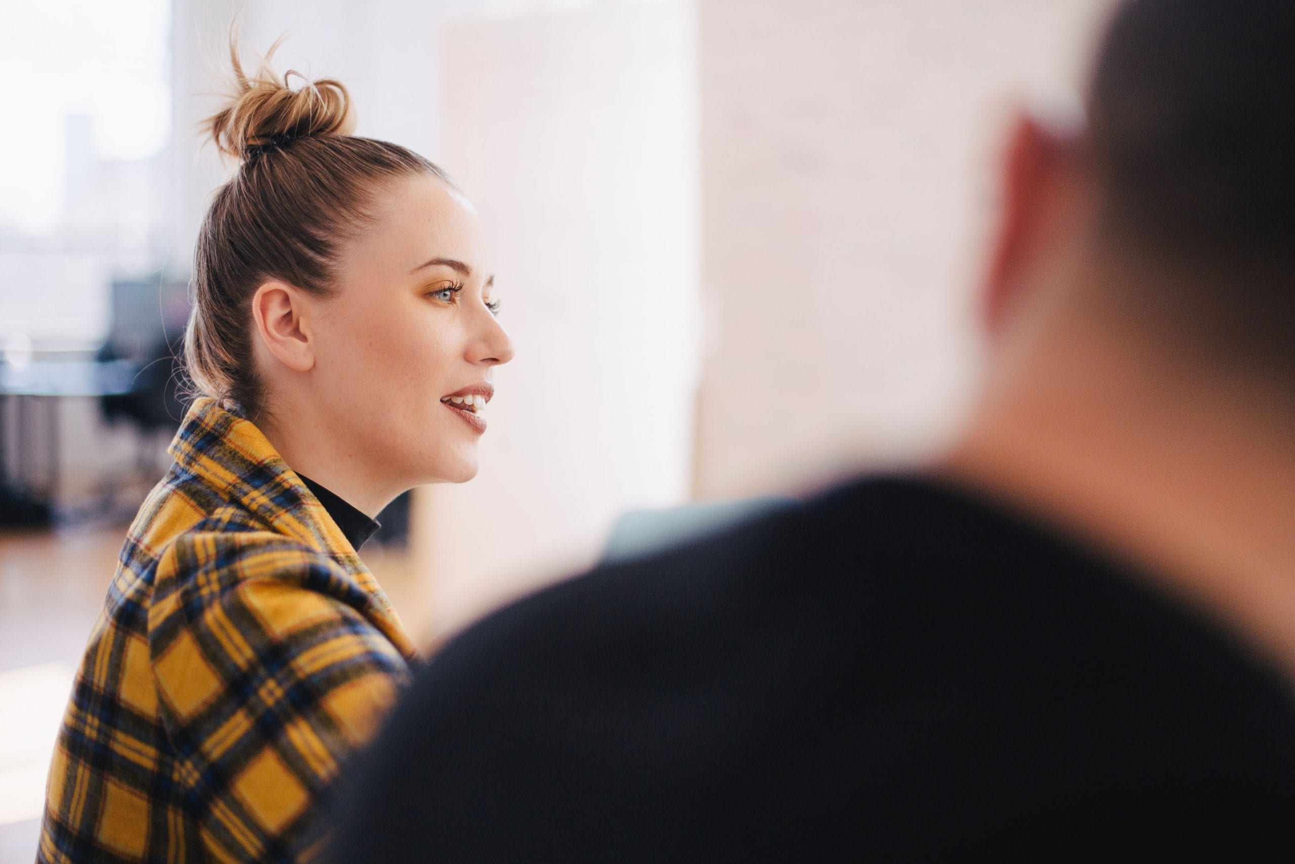 McKinsey PEI Questions. Picture depicts a young woman talking in a group discussion.