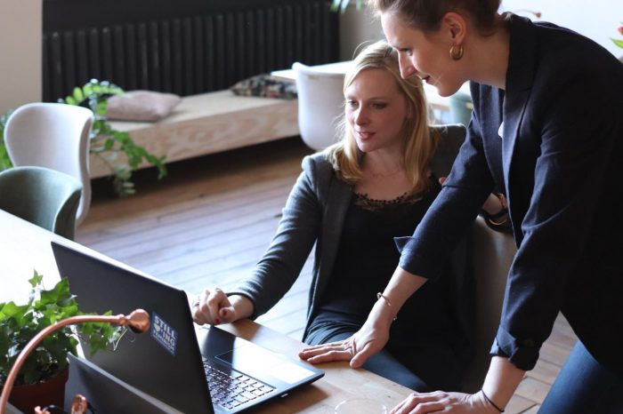 how to write a consulting resume. Picture shows 2 consultants discussing candidates.