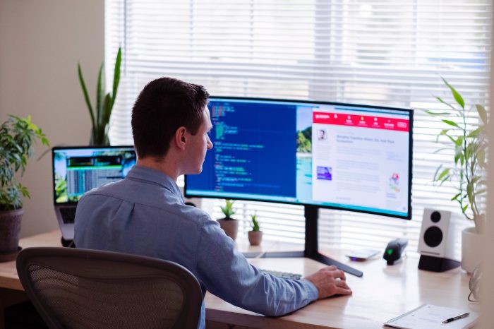 Less graphs online case interview. This image shows a man in a button-down shirt sitting in his office looking at a wide-screen computer monitor.
