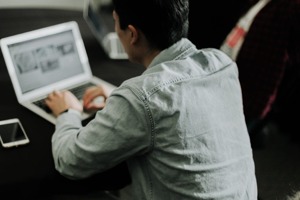 impressive consultant cover letter sample. This image shows a man working on his laptop.